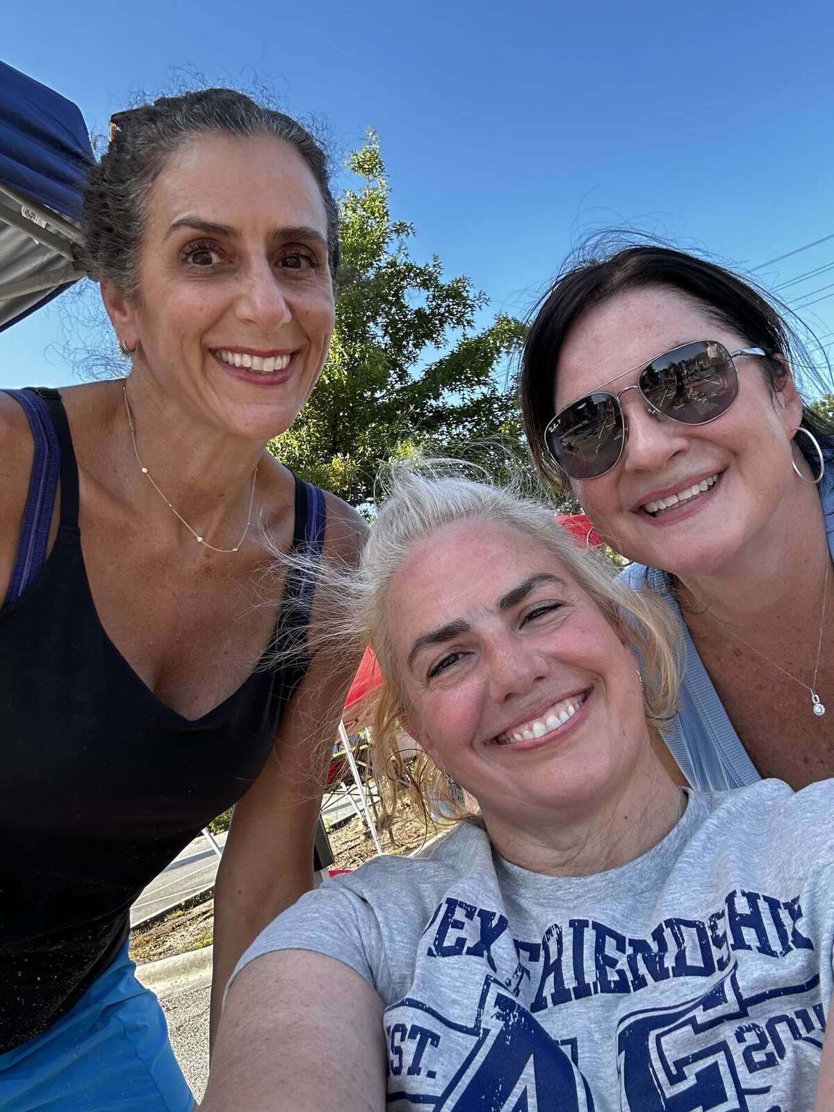 Three senior committee volunteers at chalk decorating on a sunny Sunday evening