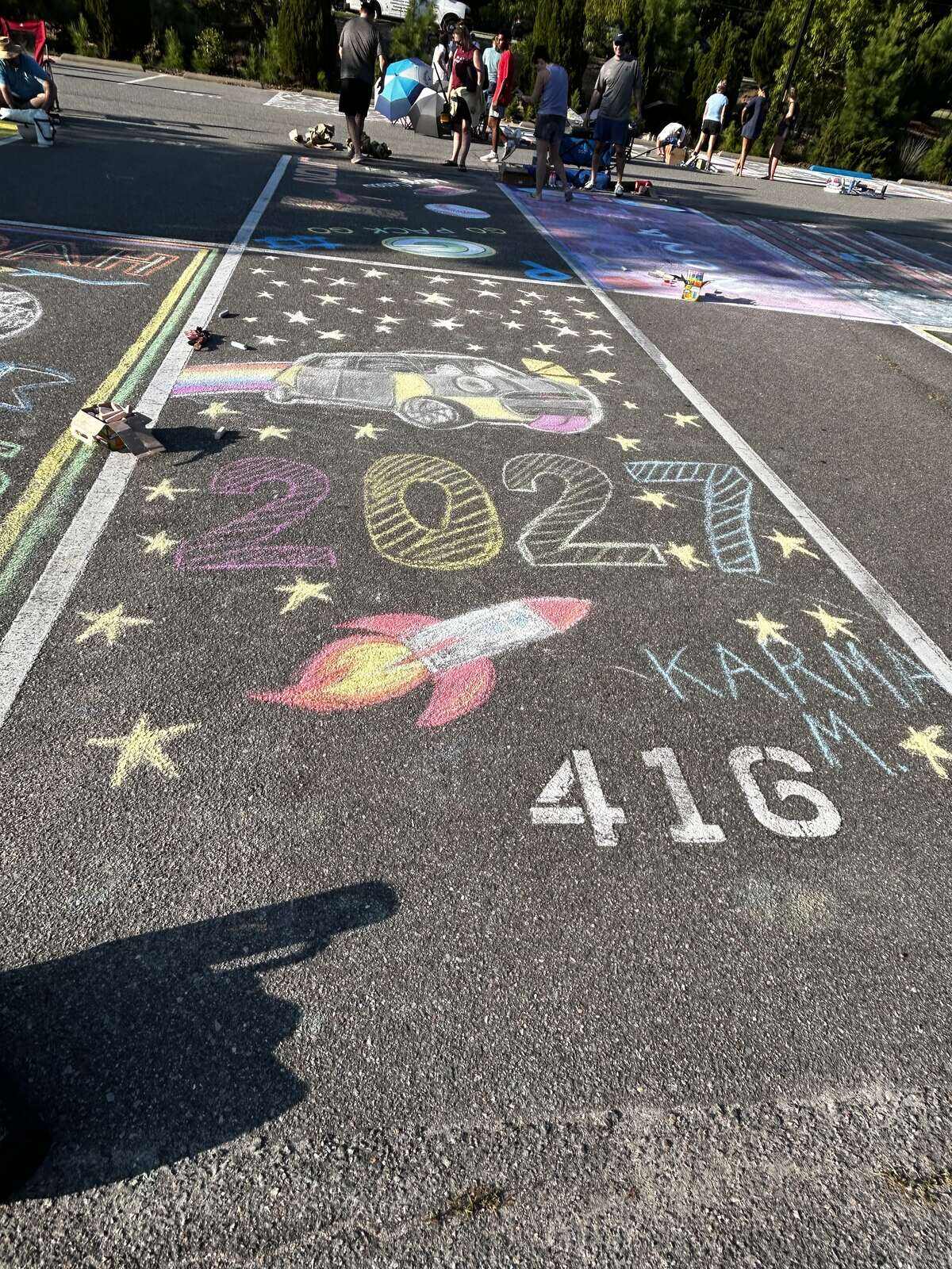 A chalked space with a car, a rocket and stars around the year 2027