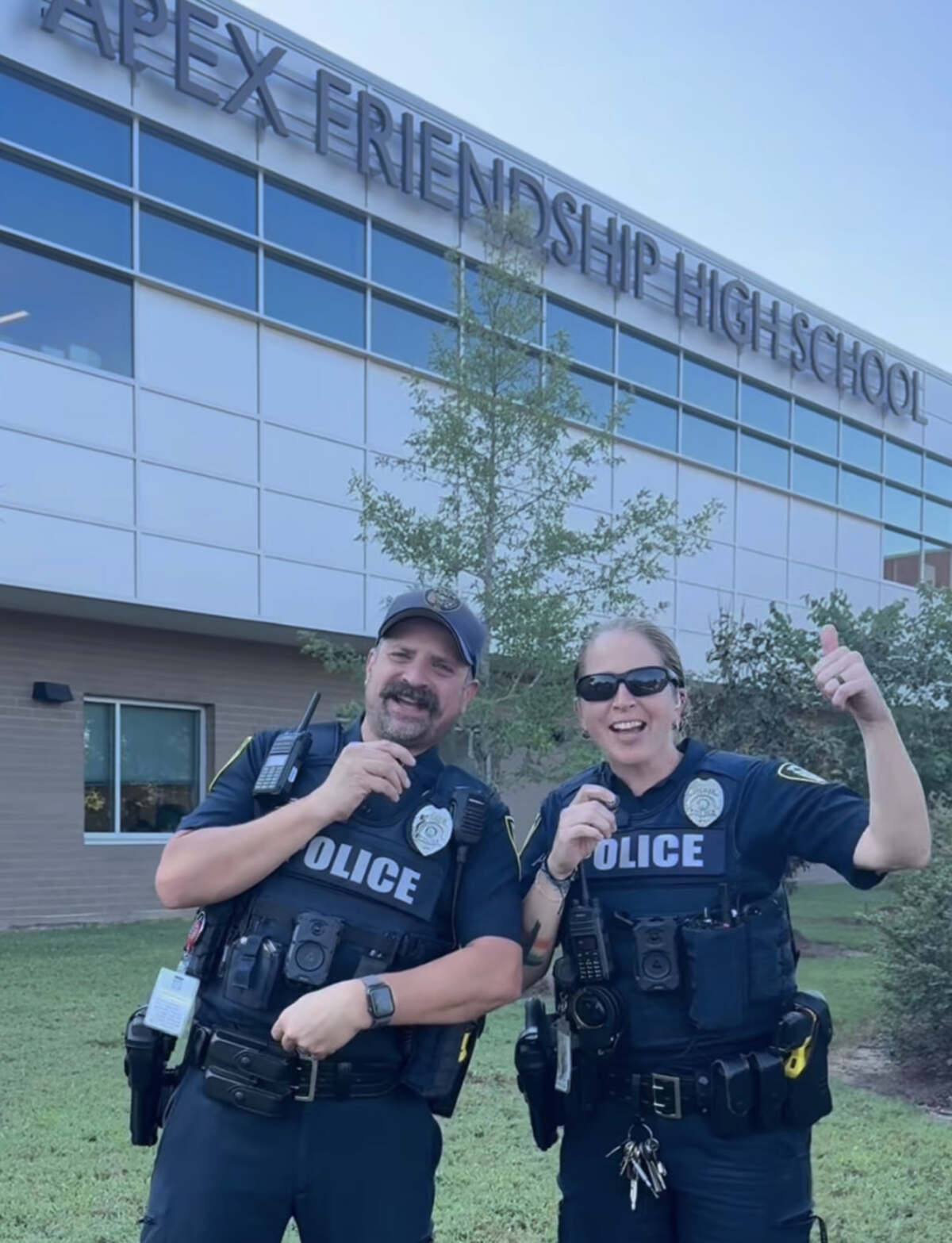 Two Apex Police School Resource Officers in uniform outside the Apex Friendship High School entrance