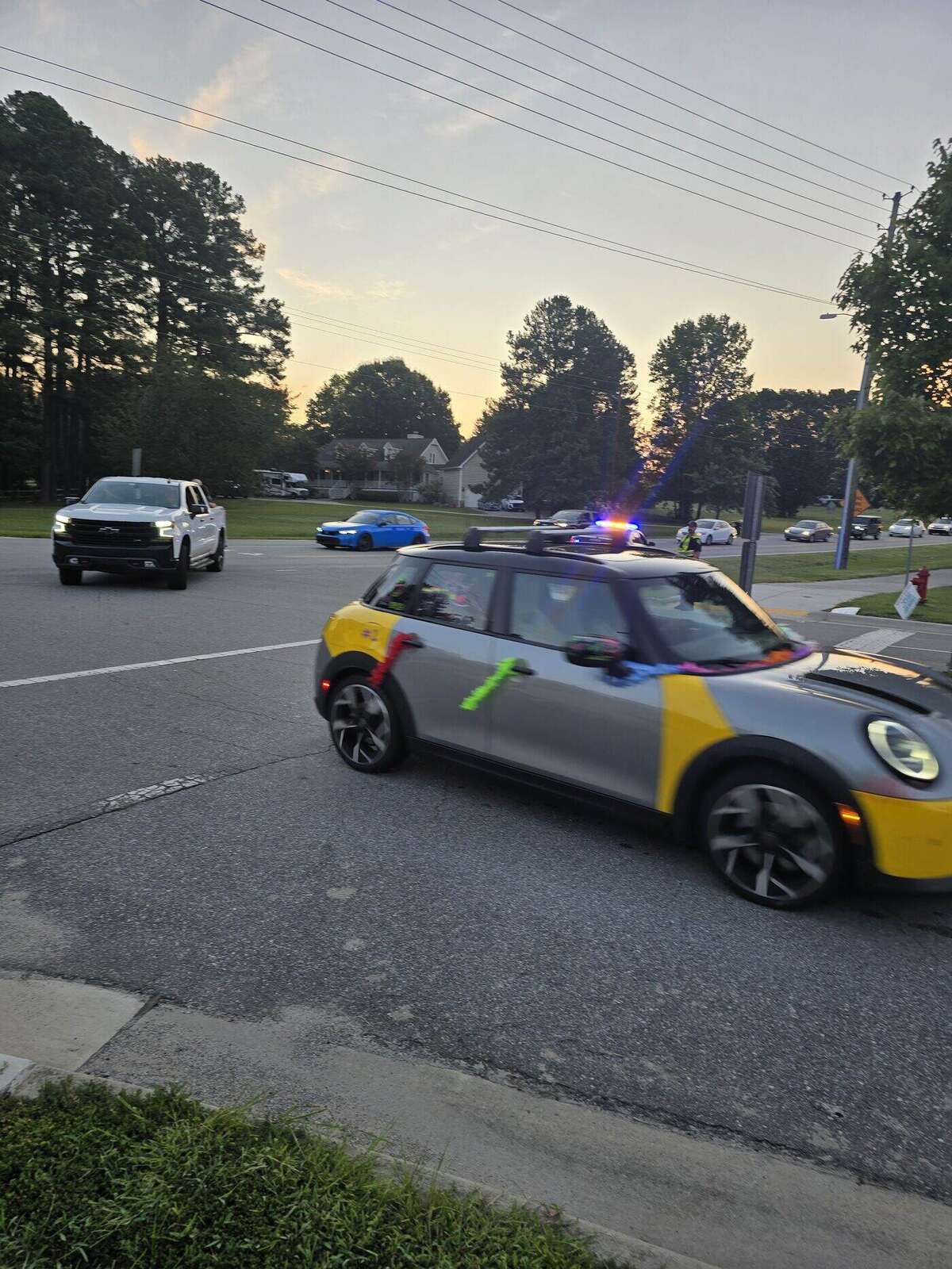 A yellow and grey Mini Cooper decorated for the parade