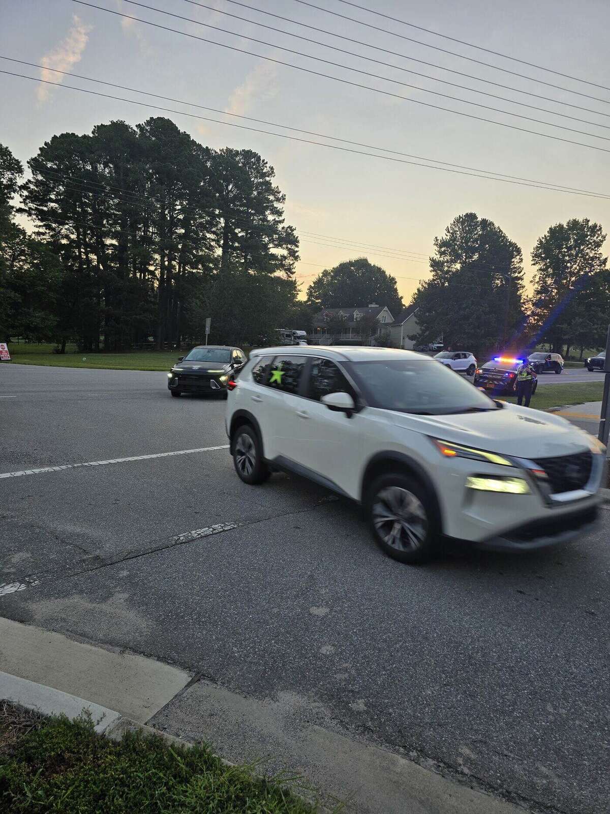 A decorated senior SUV crossing the intersection with officers and patrol cars holding traffic behind it