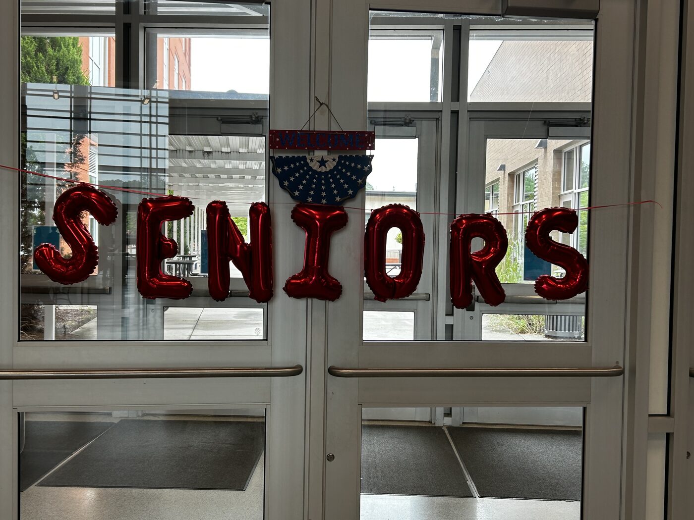 Red SENIORS balloon letters strung across the school entrance doors